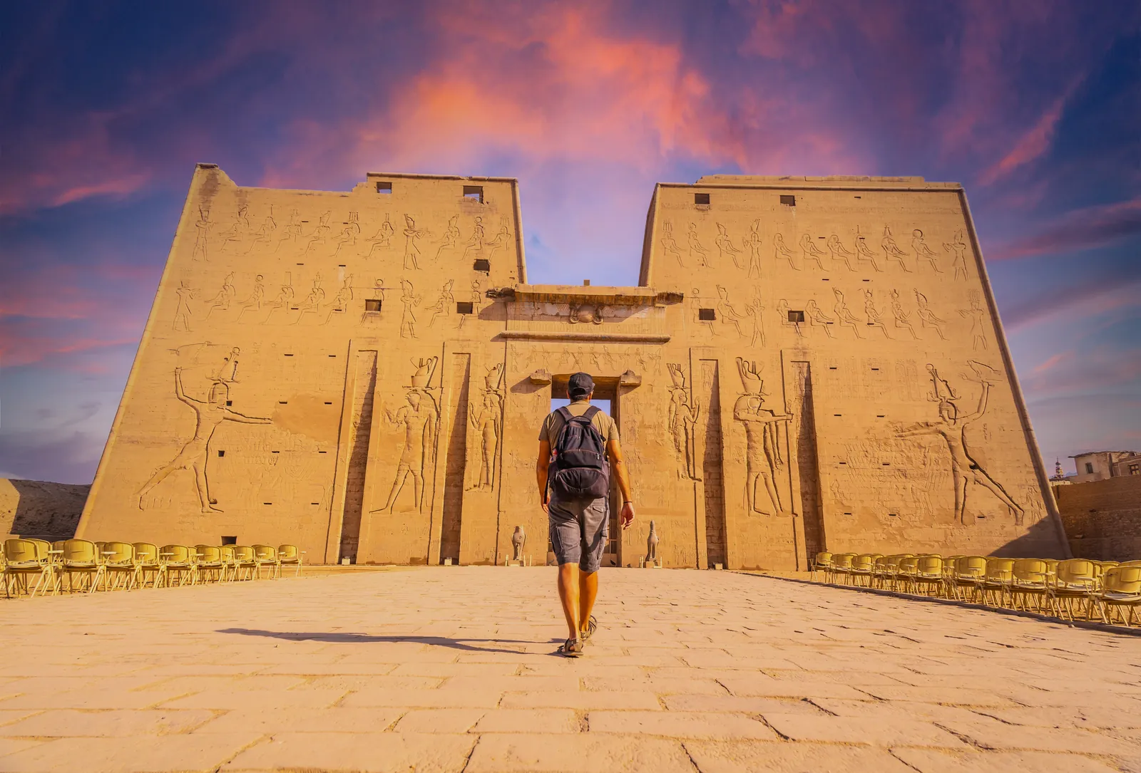 A traveller walking towards the entrance pylon of the Temple of Horus at Edfu, Egypt
