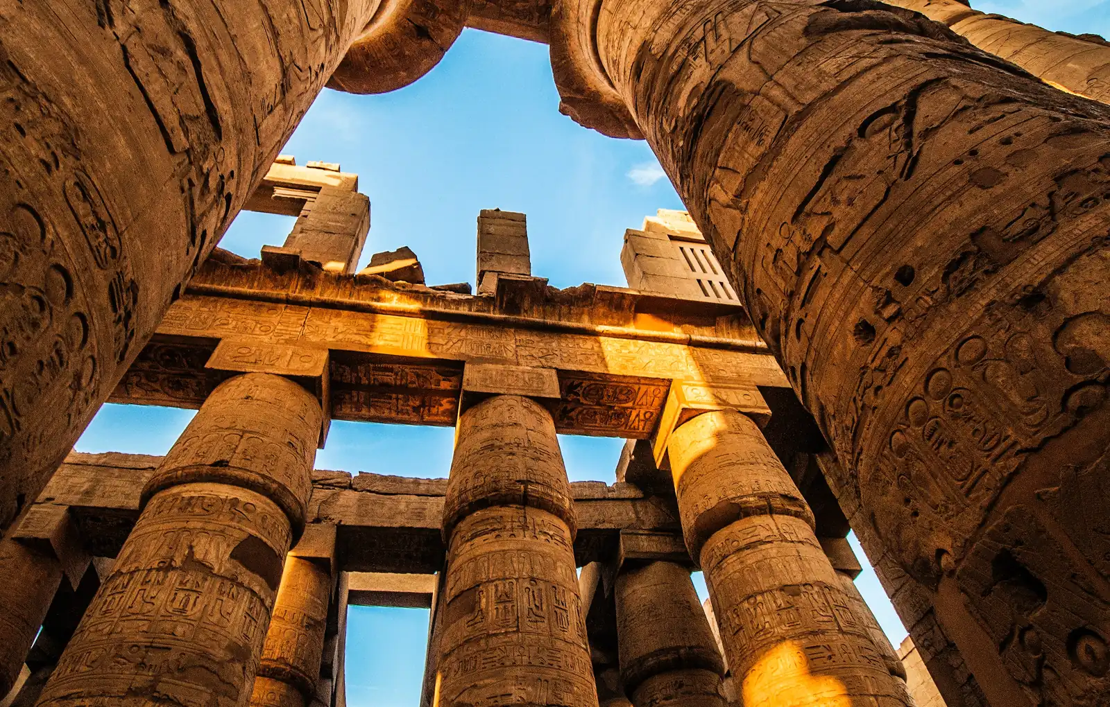 Looking up at the giant carved columns of the Hypostyle Hall at Karnak Temple, Luxor, Egypt